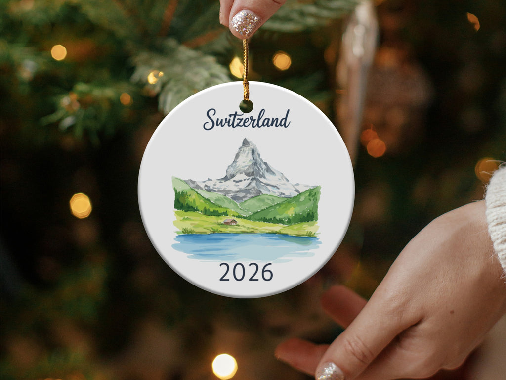 Round ornament with Switzerland and 2026, depicting a mountain landscape.