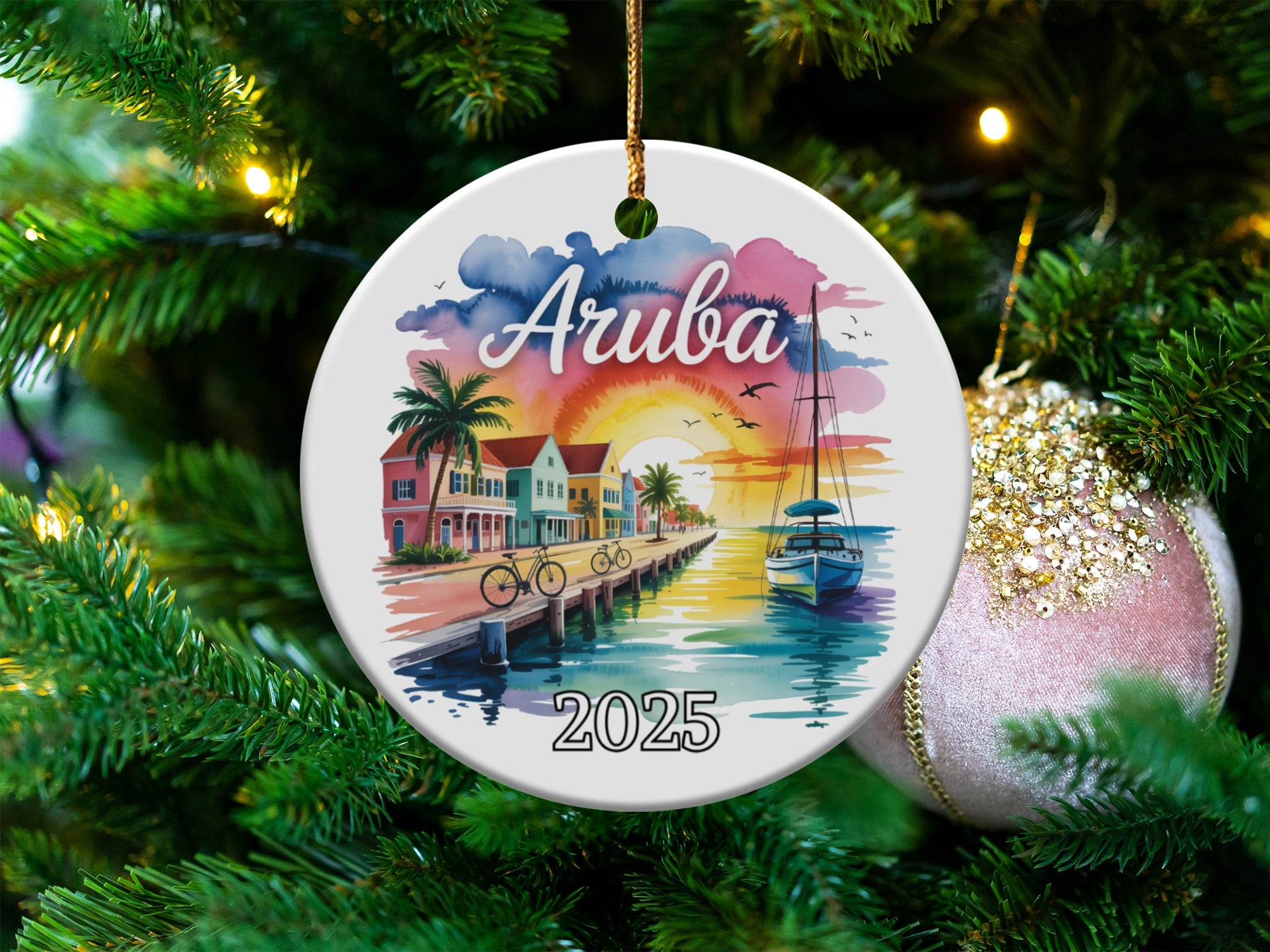 Round ornament with watercolor painting of Aruba coastline, palm trees, buildings, and boat, dated 2025.