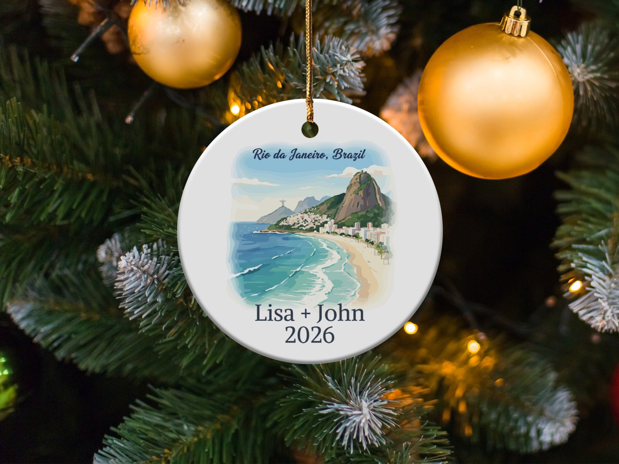 Round ornament depicting Rio de Janeiro beach scene with text "Lisa + John 2026".