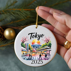 Round ornament with Tokyo cityscape, cherry blossoms, train, and "2025" text.