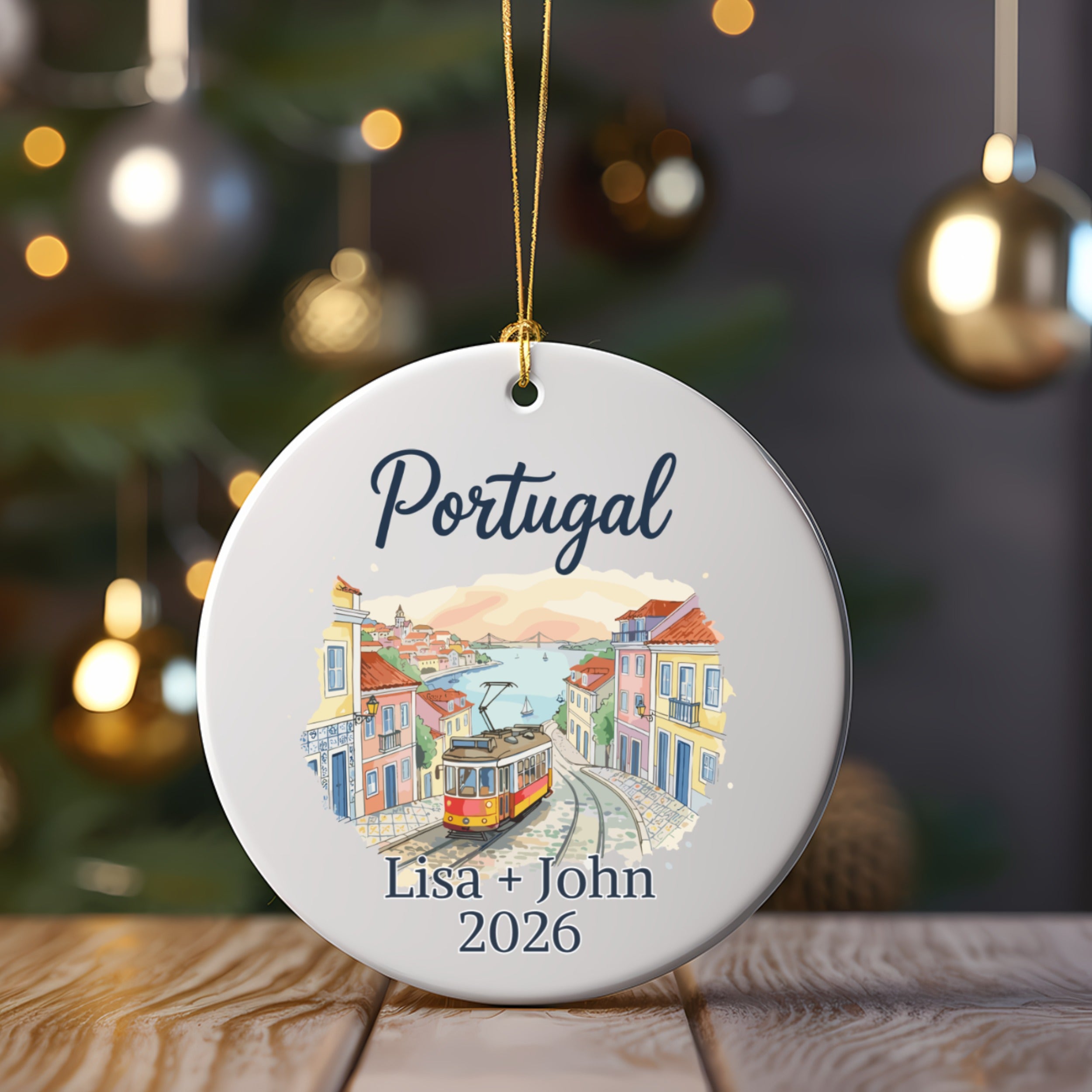 Christmas ornament with "Portugal" and "Lisa + John 2026" above a tram scene.