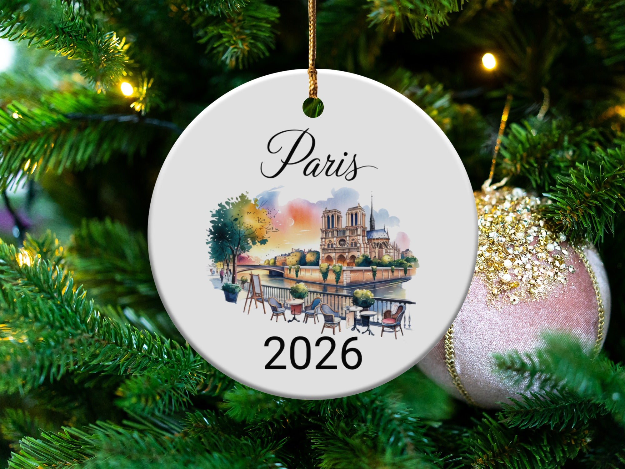 Round ceramic ornament with watercolor Paris scene and "Paris 2026" text.