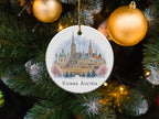 Round ornament with Vienna Austria cityscape watercolor, hanging on a Christmas tree.