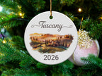 Ceramic ornament with "Tuscany 2026" and watercolor landscape scene.