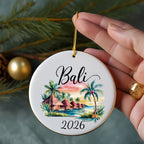 Round ornament with "Bali 2026" and tropical huts illustration.