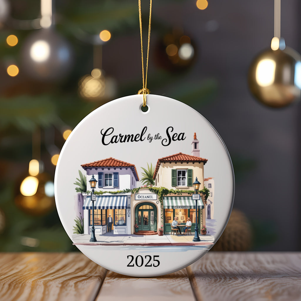 Round ornament with a watercolor scene of Carmel-by-the-Sea shops, dated 2025.