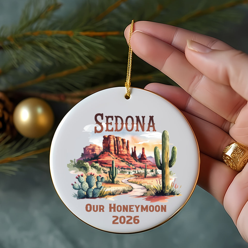 Round ornament with Sedona landscape, cactus, and "Our Honeymoon 2026" text.