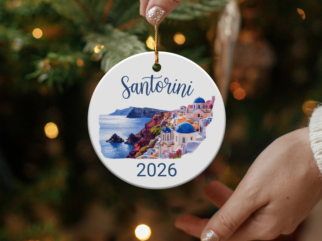 Santorini 2026 ornament with white buildings and blue domes on a cliffside.