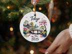 Round ornament with Tokyo skyline, bridge, cherry blossoms, and fish.