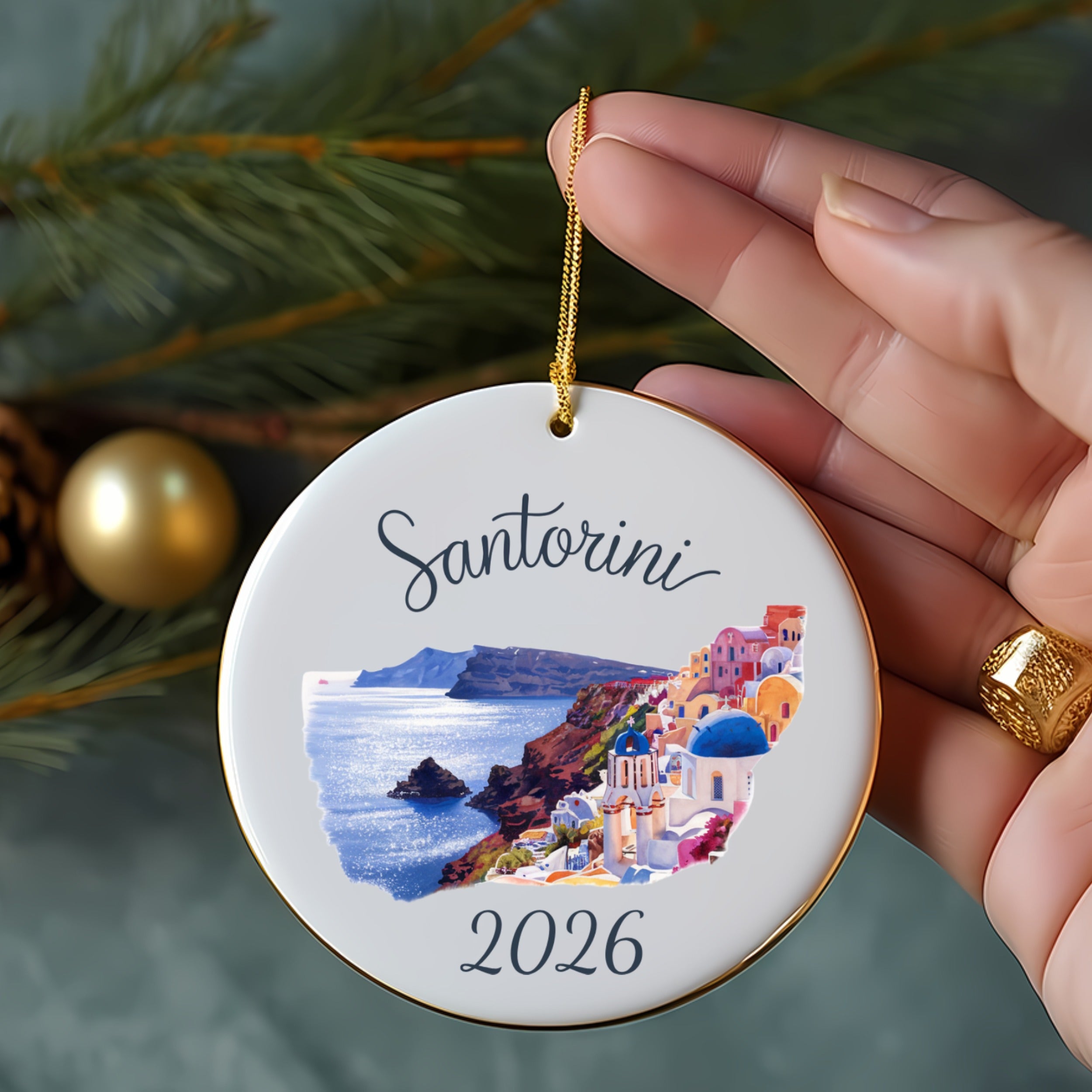 White circular ornament with Santorini scene and "2026" text.