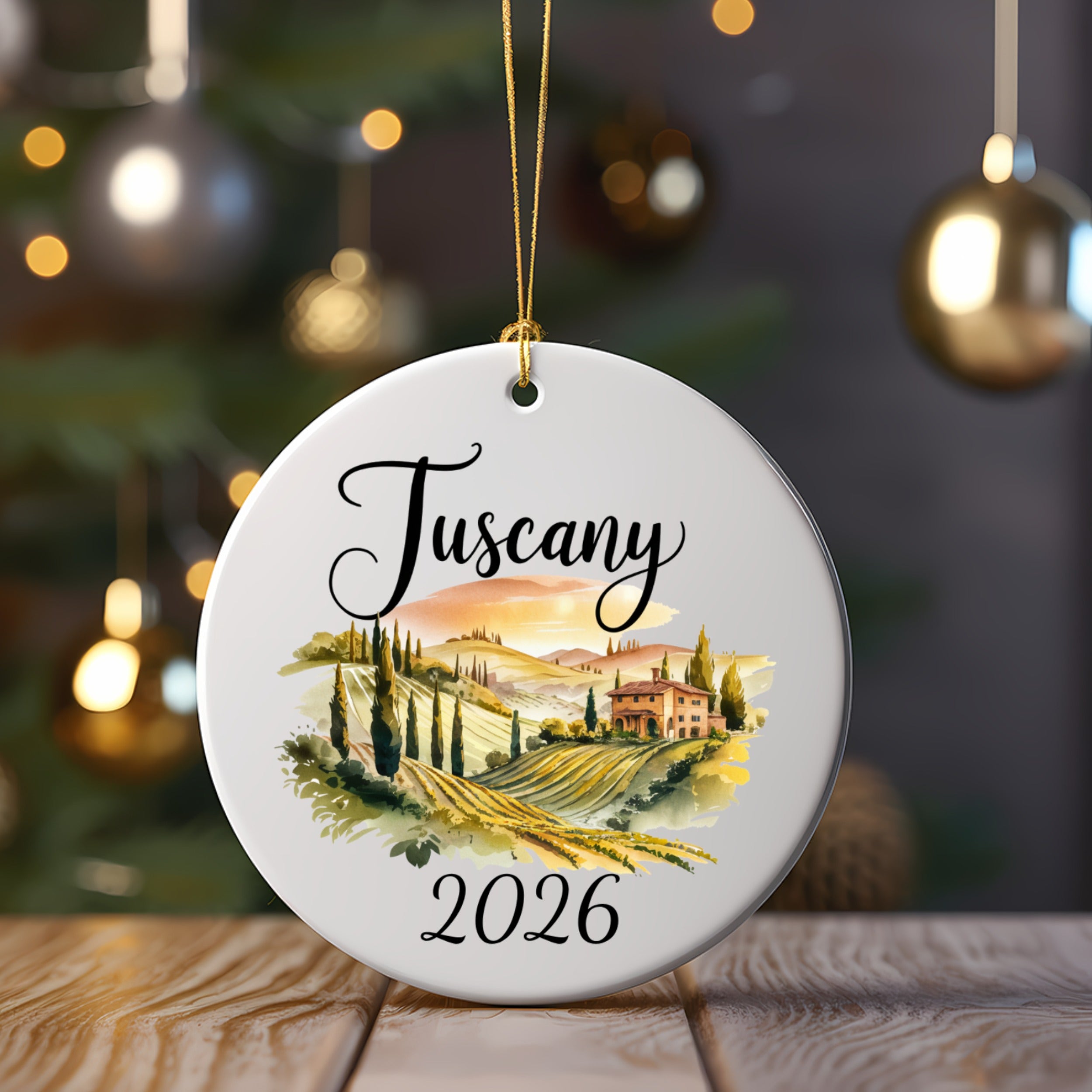 Round ornament with "Tuscany 2026" and a landscape of rolling hills.