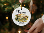 Round ceramic ornament with Tuscany landscape and "2026" text.