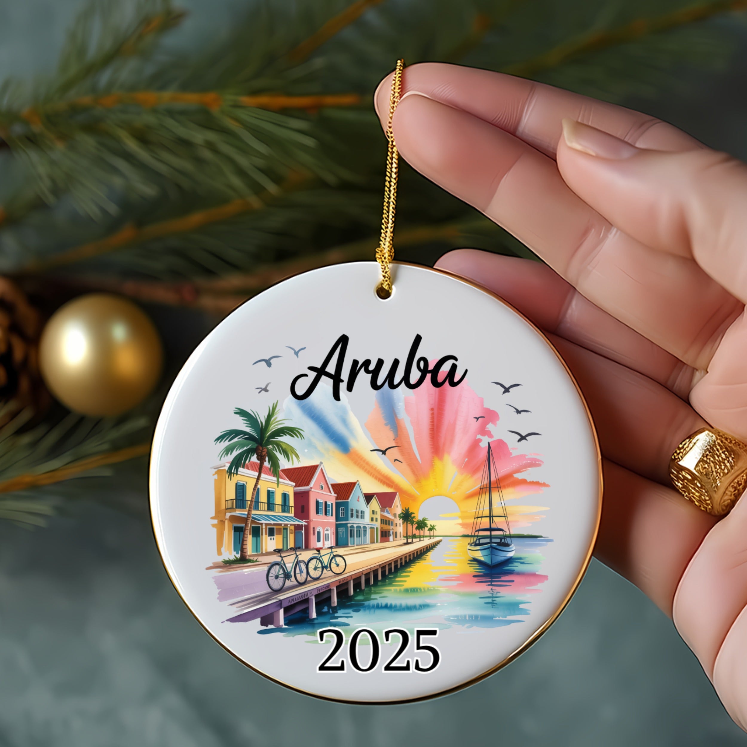 Aruba 2025 ornament with beach houses, palm trees, sailboat, and sunset.