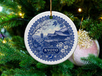 Round ceramic ornament with blue Kyoto Japan pagoda and cherry blossom design.