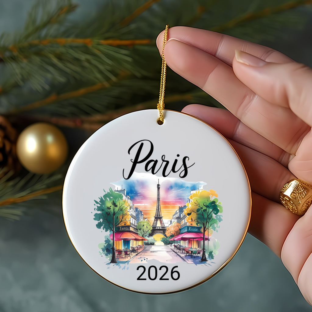 Round ornament featuring watercolor Eiffel Tower scene and "Paris 2026" text.