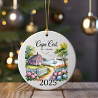 Ceramic ornament with Cape Cod 2025 scene: house, fence, water, and sailboats.