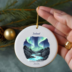 Round ornament with Iceland and aurora borealis scene, personalized with names and year.