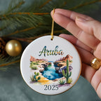 Aruba 2025 ceramic ornament featuring a desert landscape with cacti and a stream.