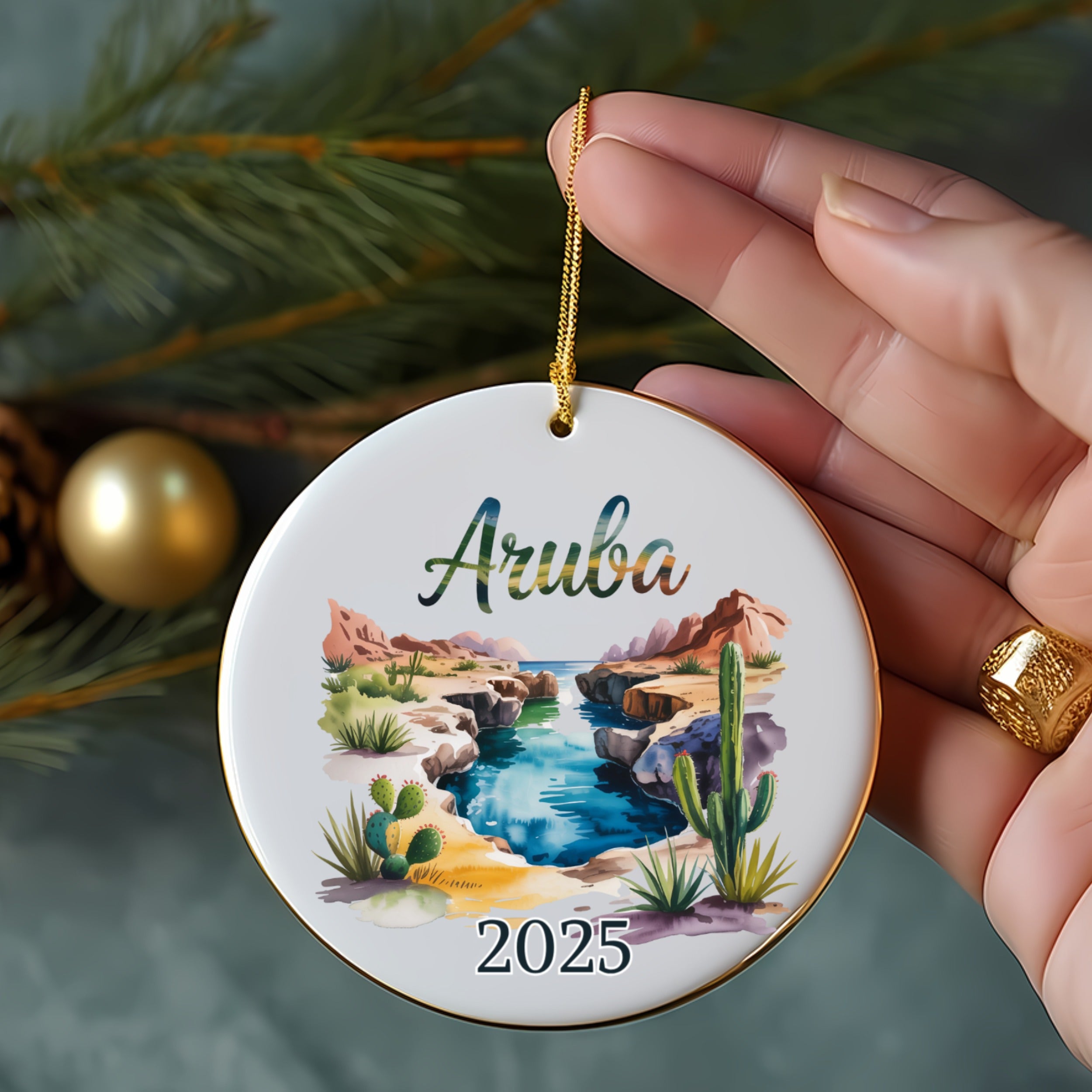 Aruba 2025 ceramic ornament featuring a desert landscape with cacti and a stream.