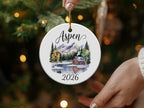 Round ornament with cabin, trees, mountains, and "Aspen 2026".