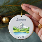 Switzerland ornament with Matterhorn, lake, and pine trees, dated 2026.