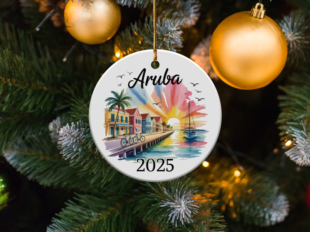 Round ornament depicting Aruba 2025 with a sailboat and colorful buildings.