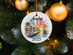 Round ornament depicting Aruba 2025 with a sailboat and colorful buildings.
