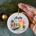 Aruba honeymoon ornament with colorful houses, palm trees, sailboat, and sunset.