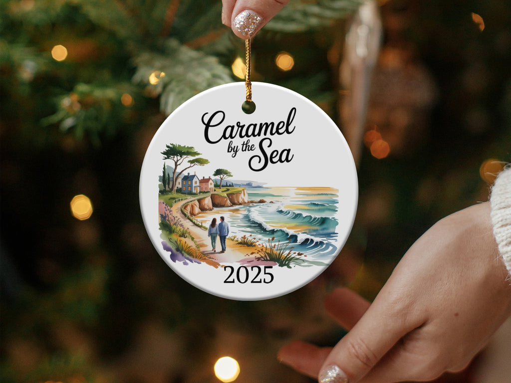 Round ornament with "Caramel by the Sea" and "2025" above a coastal scene.