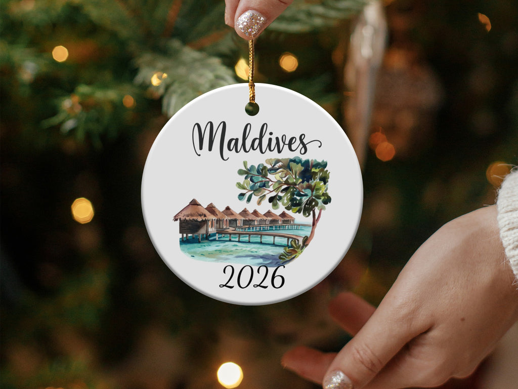 Maldives 2026 circular ornament with overwater bungalows and palm trees.