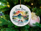 Bora Bora 2025 ornament with palm trees, water bungalows, and colorful sunset over mountains.