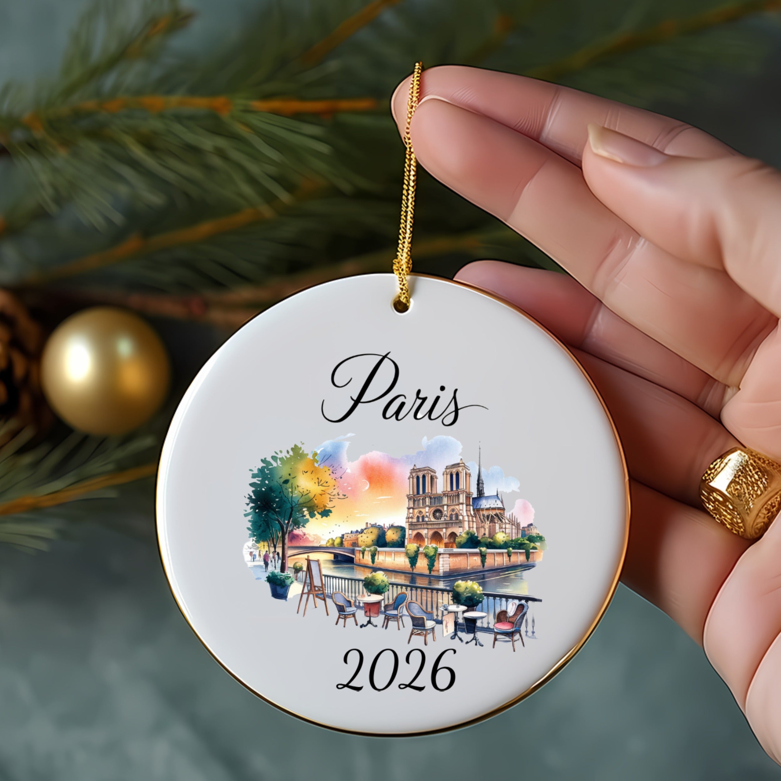 Round ceramic ornament featuring Notre Dame cathedral and city scene, dated 2026.