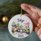 Round ornament with Tokyo and 2025 text, bridge, and cherry blossoms.