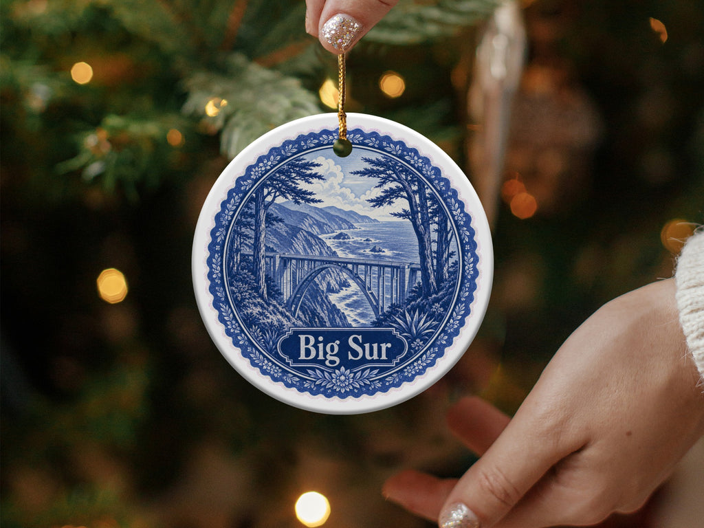 Round ceramic ornament featuring a blue and white scene of Bixby Bridge and the Big Sur coast.
