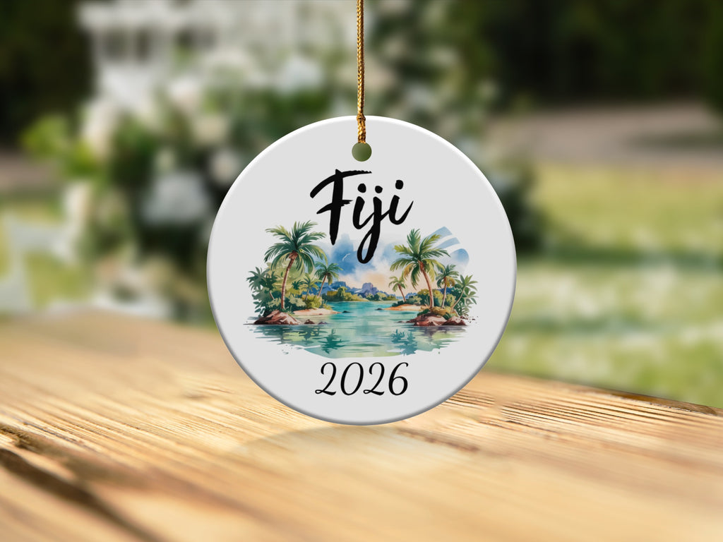Round ceramic ornament with "Fiji 2026" and a tropical island scene.