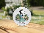 Round ceramic ornament with "Fiji 2026" and a tropical island scene.