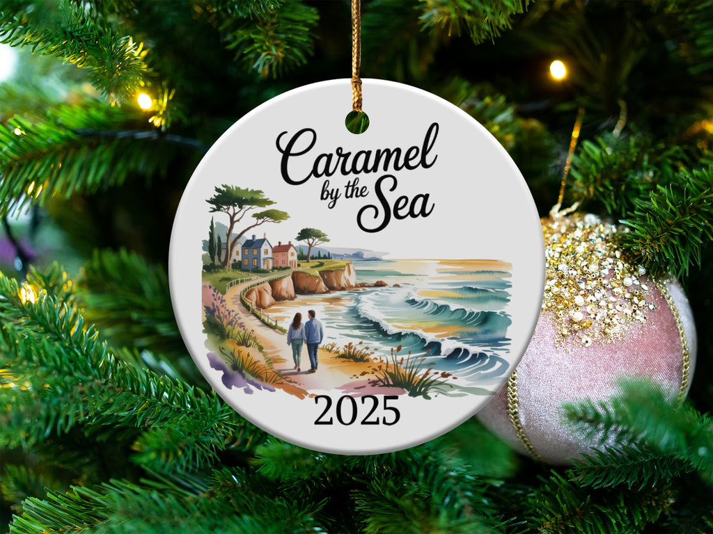 Round ceramic ornament with coastal landscape and "Caramel by the Sea 2025".