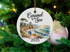 Round ceramic ornament with coastal landscape and "Caramel by the Sea 2025".