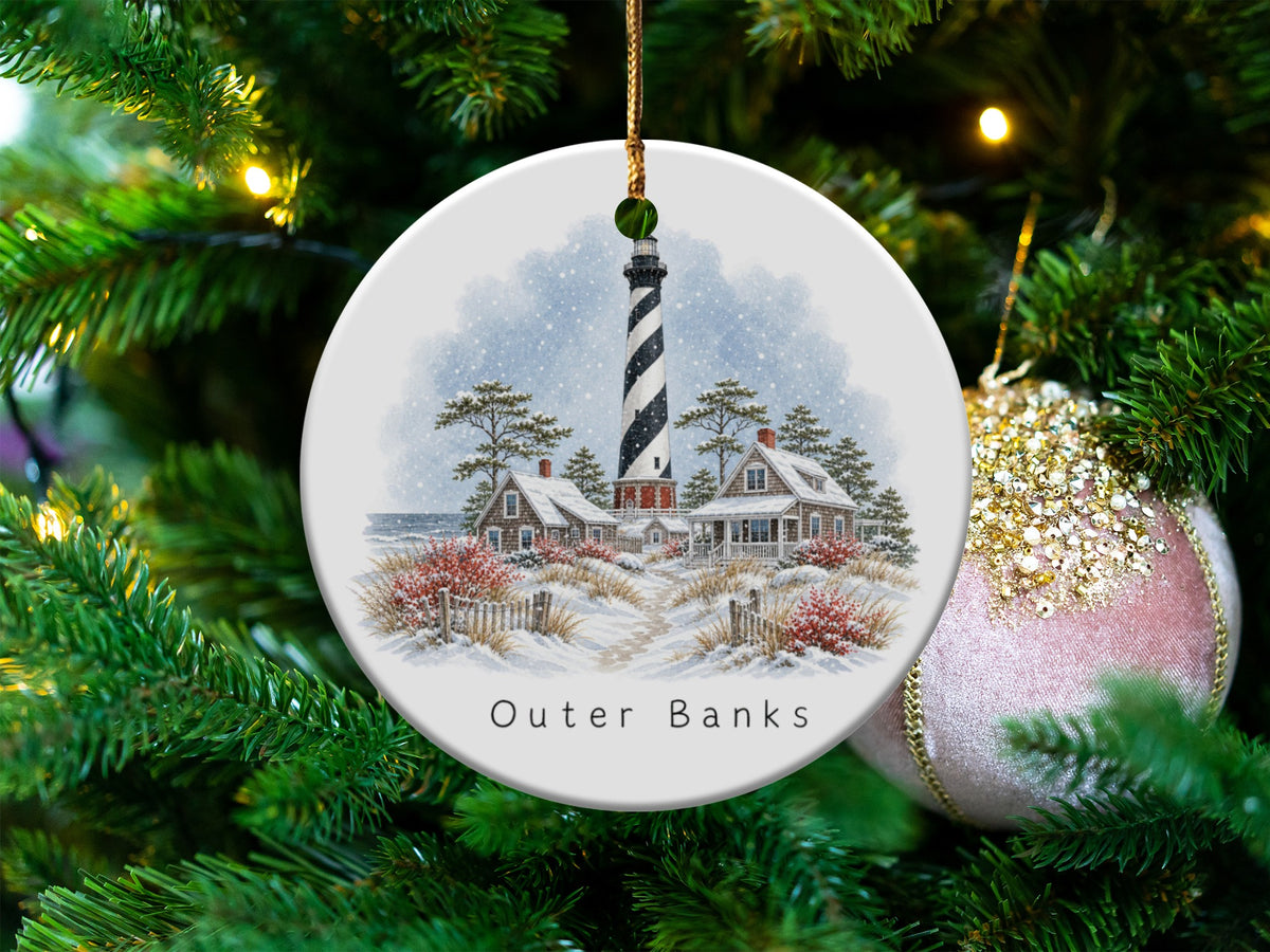 Christmas ornament with Outer Banks lighthouse, cottages, and snowy landscape.