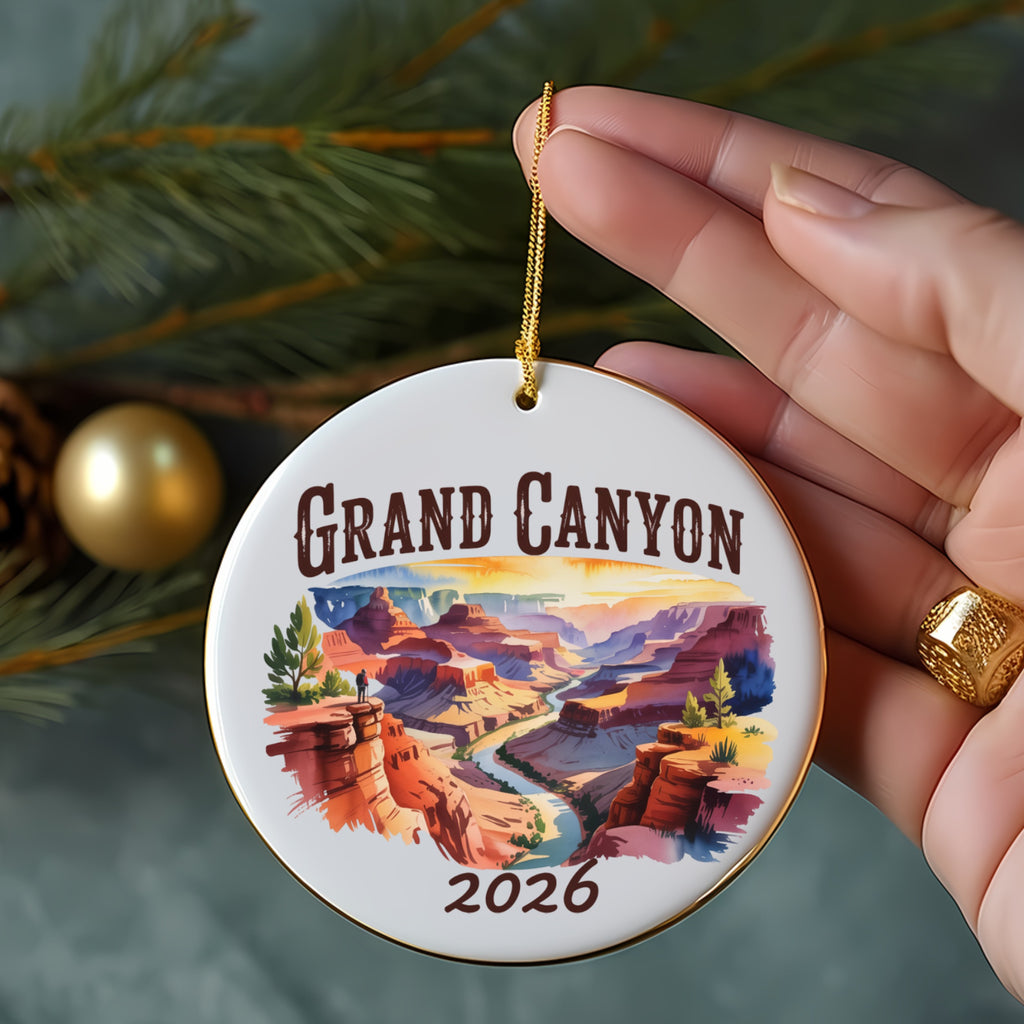 Grand Canyon 2026 ornament with a hand holding it.