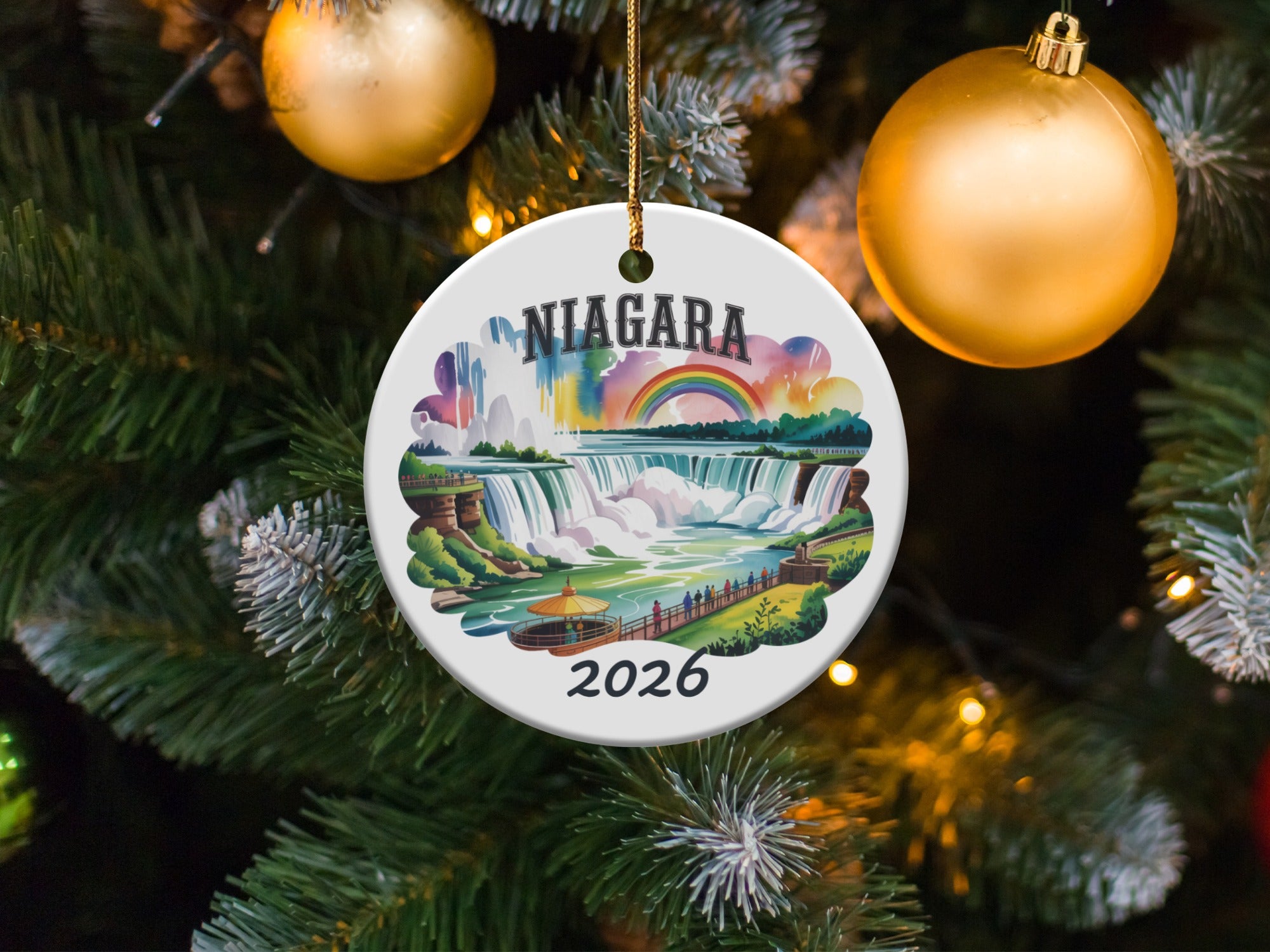 Niagara Falls ornament with rainbow, "2026" text, hanging on a Christmas tree.