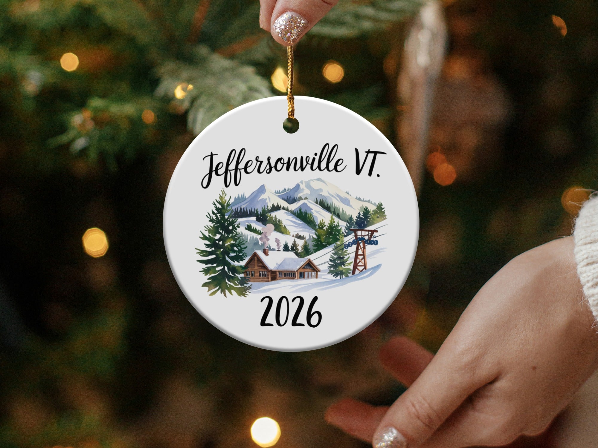 Round ceramic ornament with "Jeffersonville VT 2026" and ski village scene.