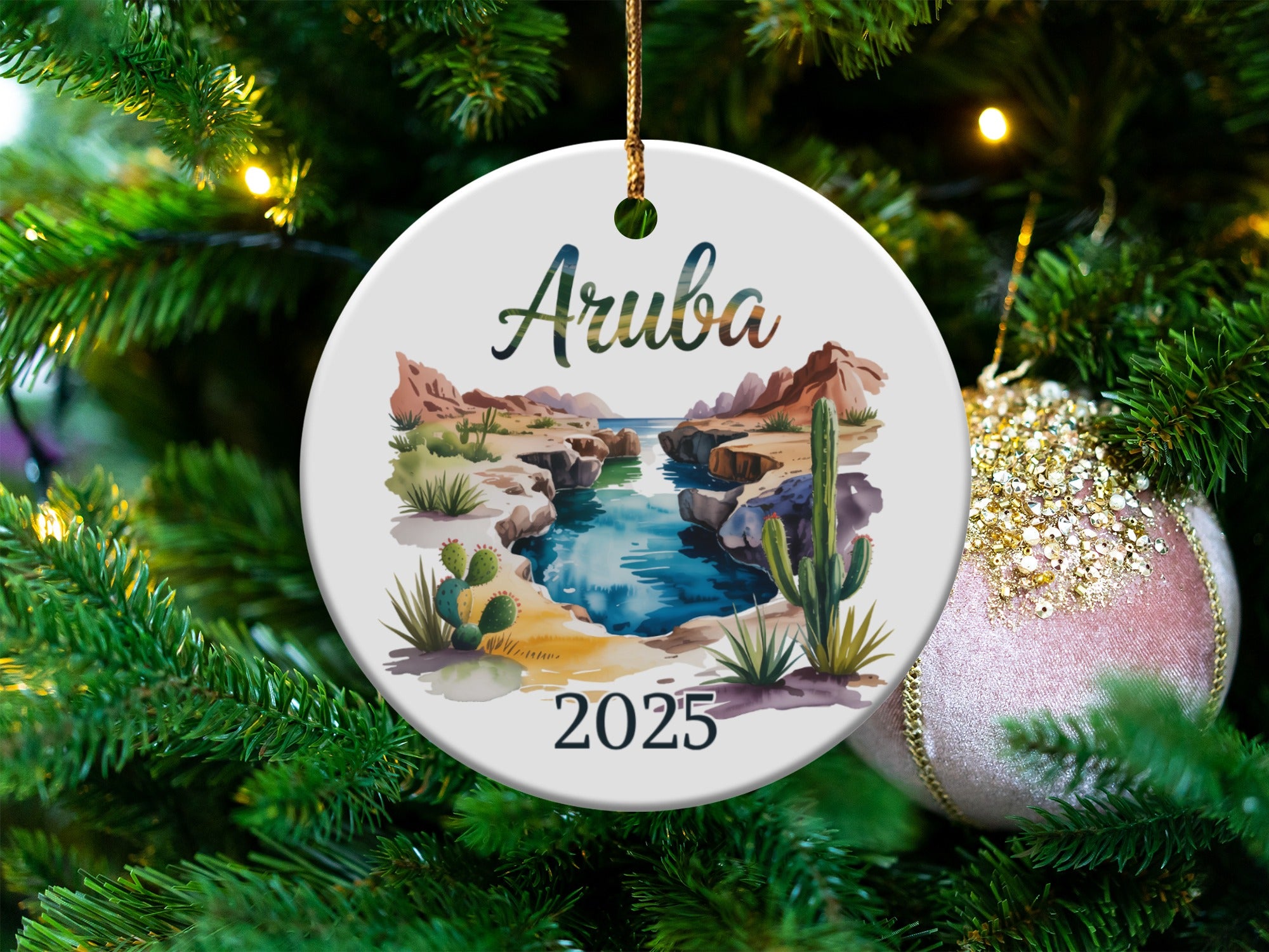 Round ornament depicting Aruba landscape with "Aruba 2025" text.