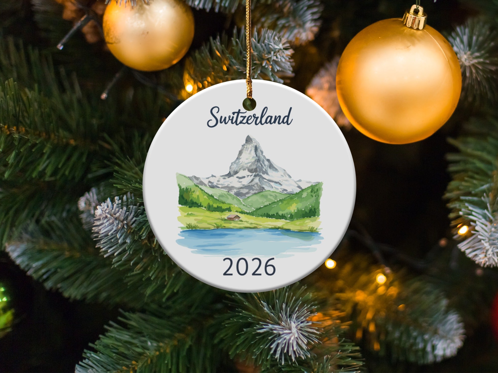 Round ornament with Matterhorn mountain scene and "Switzerland 2026" text.