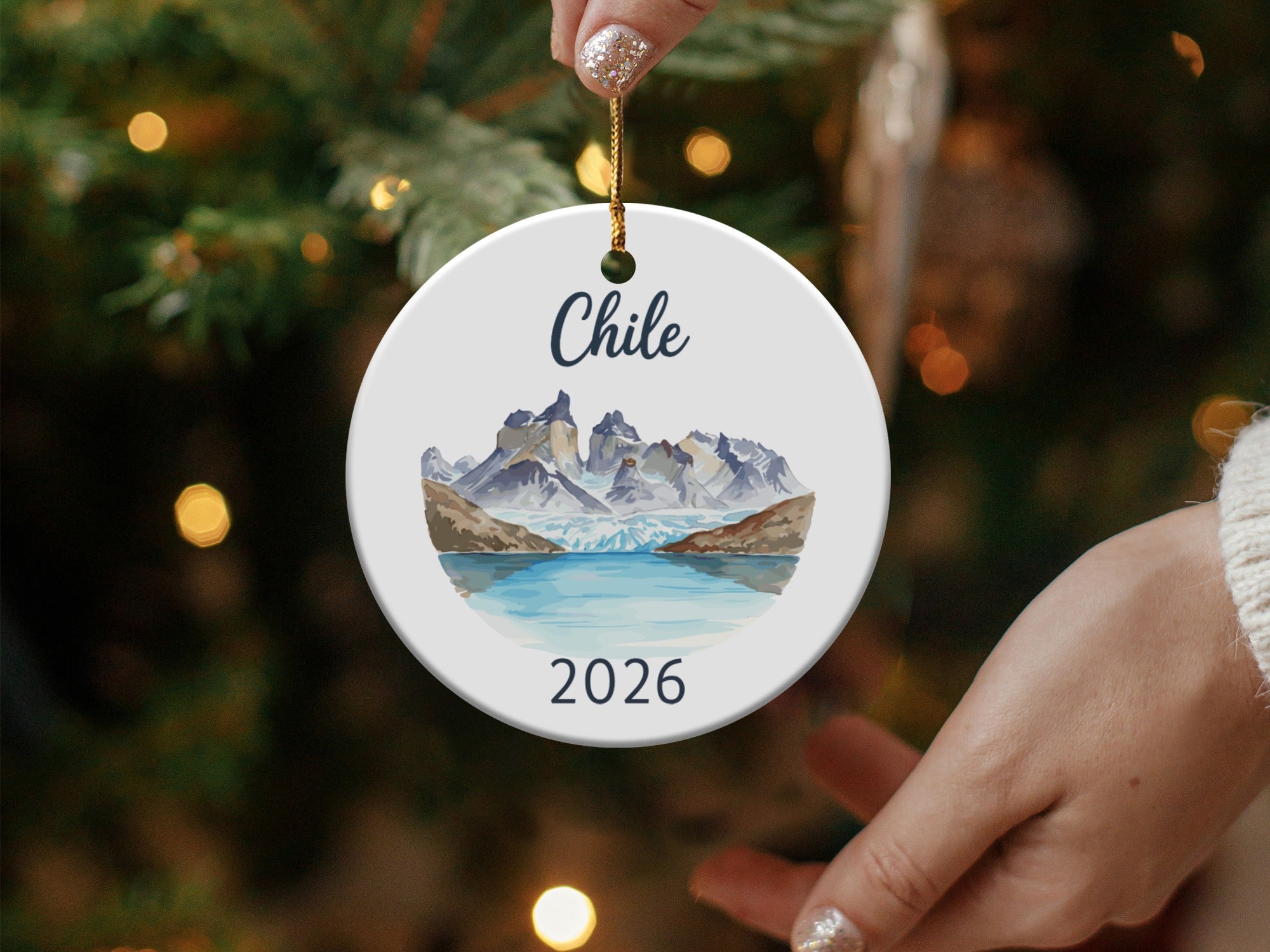 Round ornament depicting mountains and a lake with "Chile 2026" text.