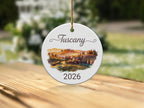 Tuscan landscape ornament with "Tuscany 2026" text.