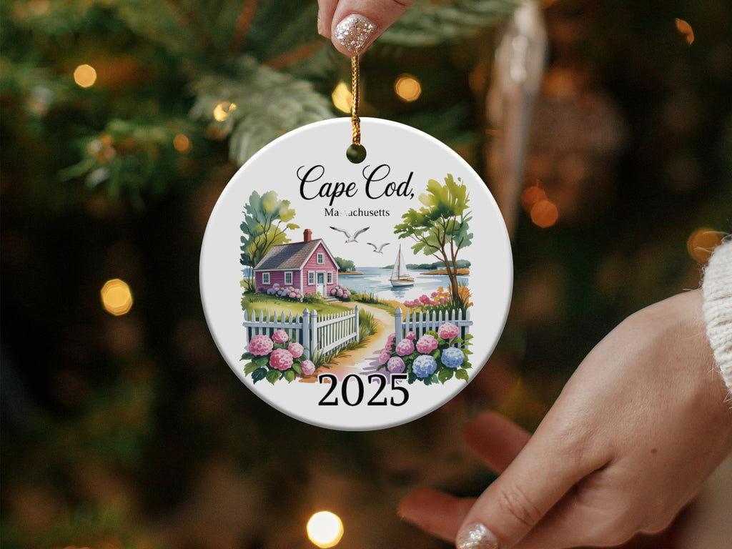 Cape Cod Massachusetts 2025 ceramic ornament with a house, fence, and sailboat.