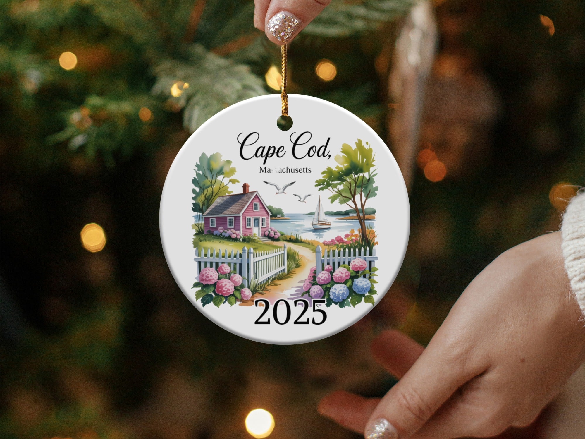 Cape Cod Massachusetts 2025 ceramic ornament with a house, fence, and sailboat.